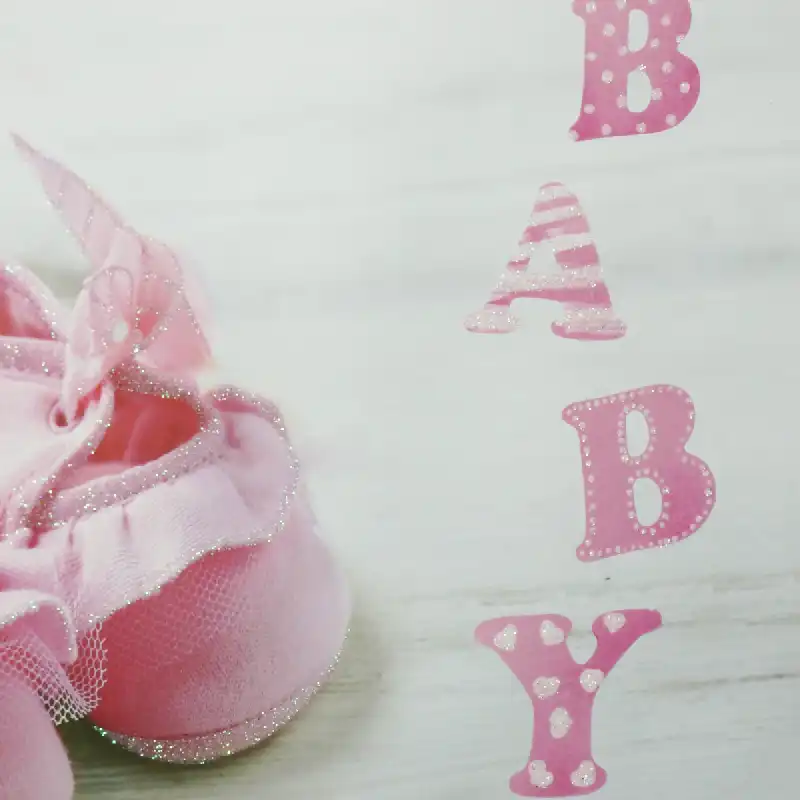 Prezentacja grafiki zdobiącej torebkę, skupiająca się na detalach nadruku bucików i estetycznym liternictwie motywu BABY.
