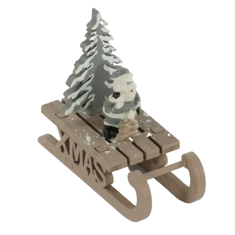 Świąteczna figurka sanki o wysokości 9 cm z figurką Mikołaja i choinką. Dekoracyjne sanki z napisem XMAS to idealne figurki ozdobne do wnętrz.