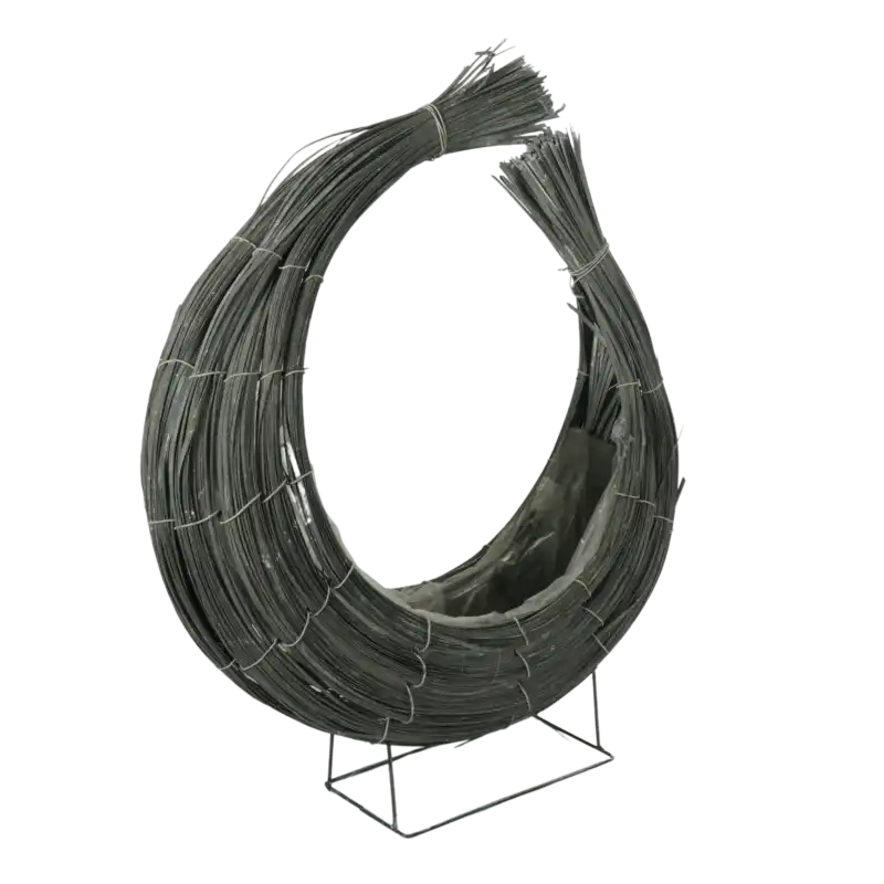 Rattanowy kosz dekoracyjny w kształcie rogala o wysokości 50 cm. Widoczna metalowa podstawa oraz folia wewnątrz osłonki ułatwiająca sadzenie kwiatów.