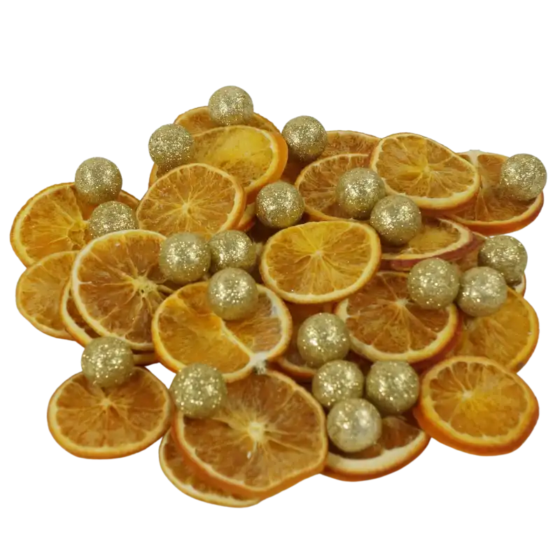 Artykuły dekoracyjne w formie złotych kulek 2 cm, rozłożone na suszonych plastrach pomarańczy. Brokatowe wykończenie kulek dodaje blasku świątecznym dekoracjom domowym.