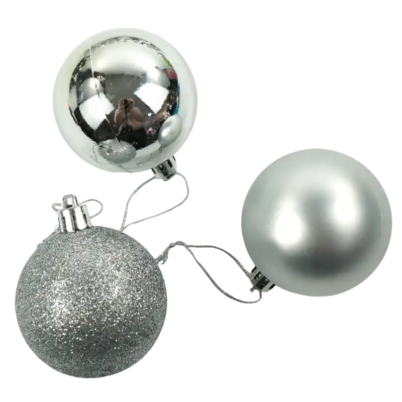 Zbliżenie na trzy srebrne bombki 6 cm z zawieszkami. Jedna jest błyszcząca, druga matowa, a trzecia w całości pokryta brokatem.