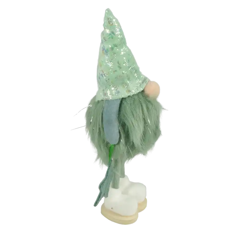 Profilowe ujęcie ozdobnej figurki skrzata. Widoczna błyszcząca miętowa czapka, futrzany tułów oraz trzymana w dłoni tekstylna gwiazdka dekoracyjna.