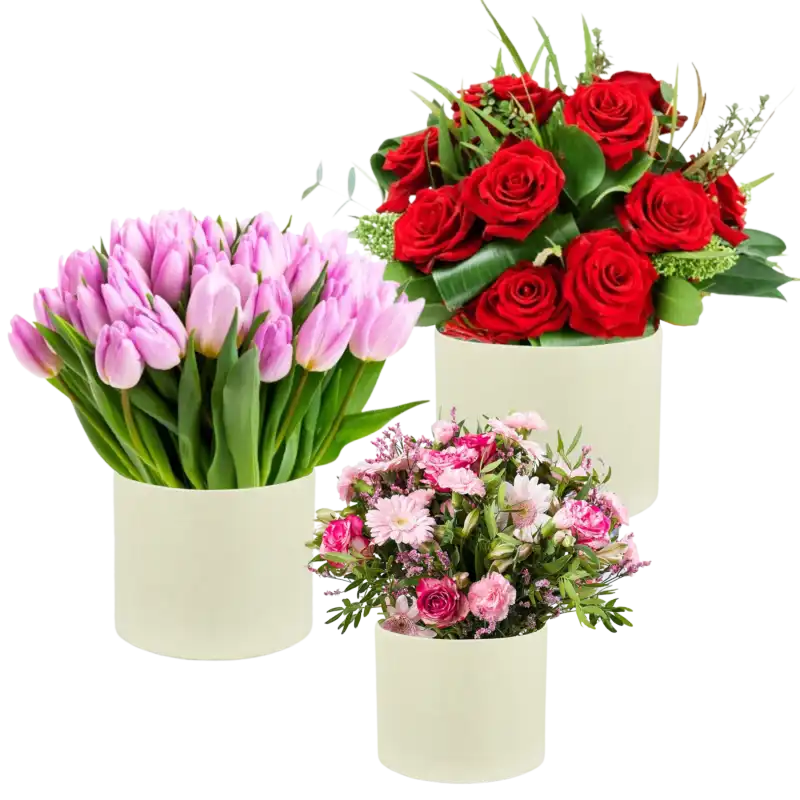 Zestaw trzech flowerboxów wypełnionych różnymi gatunkami kwiatów, w tym różami i tulipanami. Pudełka pełnią funkcję eleganckiej podstawy dla bukietów na różne okazje.