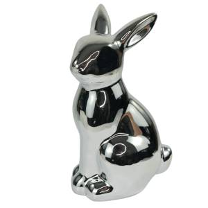 Srebrna figurka zająca ceramicznego w widoku z półprofilu. Dekoracja wiosenna o gładkiej, błyszczącej powierzchni.
