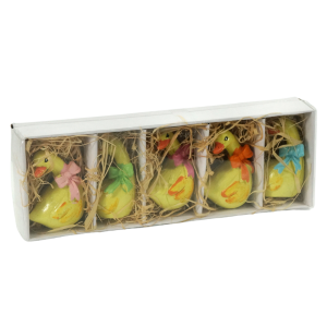 Ułożone w rzędzie figurki gęsi wewnątrz opakowania zbiorczego. Ceramiczne dekoracje z delikatnymi detalami w postaci kokardek i pomarańczowych dziobów.