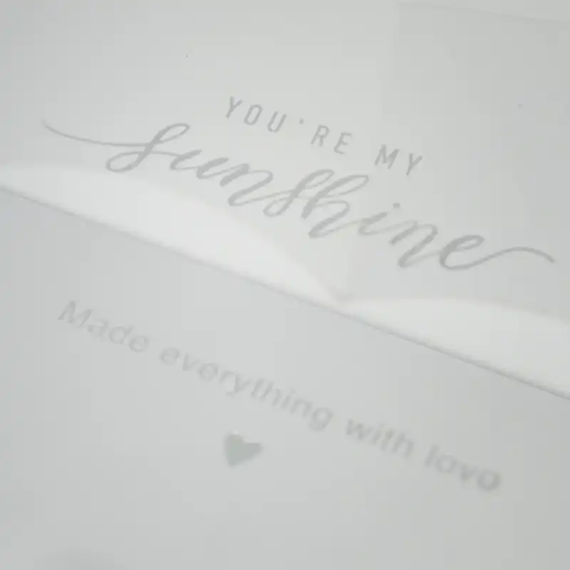 Zbliżenie na wieczko białego flowerboxa z ozdobnym napisem You are my sunshine oraz dopiskiem Made everything with love.