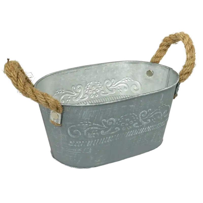 Owalna osłonka z metalu o długości 18 cm. Charakterystyczny postarzany design, jutowe uchwyty oraz wytłaczane wzornictwo roślinne na ściankach zewnętrznych.
