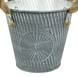 Zbliżenie na fakturę szarej metalowej osłonki 12 cm. Widoczny detal postarzanego wzoru oraz mocowanie uchwytów do korpusu.