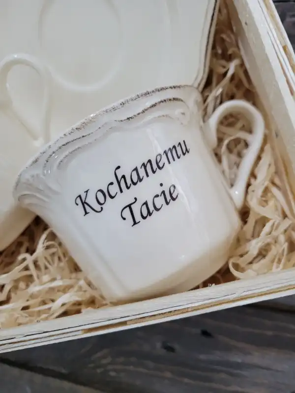 Detale filiżanki z napisem Kochanemu Tacie wewnątrz koszyka wypełnionego wełną drzewną.