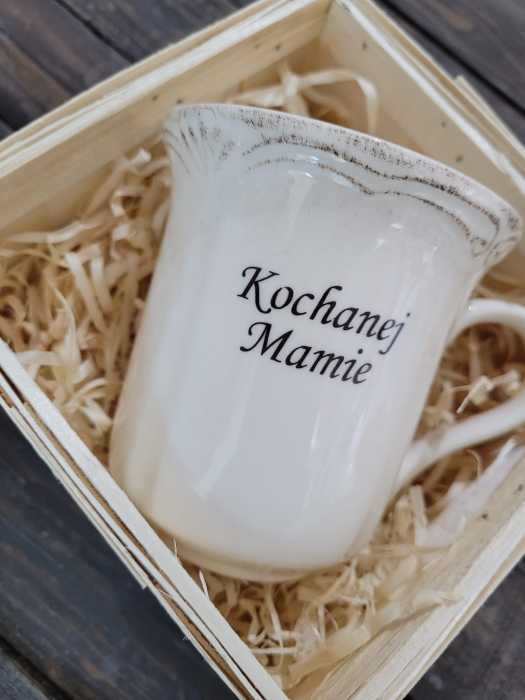Zbliżenie na ceramiczny kubek o wysokości 11 cm z nadrukiem Kochanej Mamie. Widoczny postarzany styl wykończenia krawędzi.