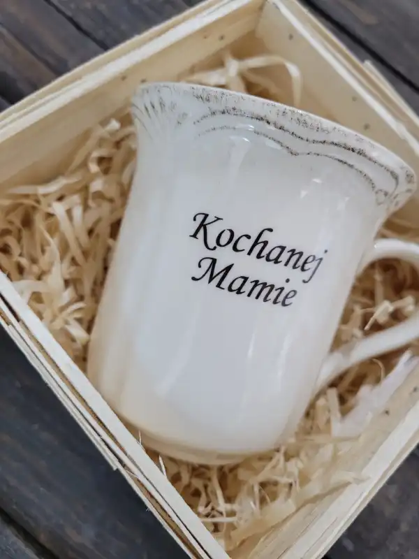Zbliżenie na ceramiczny kubek o wysokości 11 cm z nadrukiem Kochanej Mamie. Widoczny postarzany styl wykończenia krawędzi.