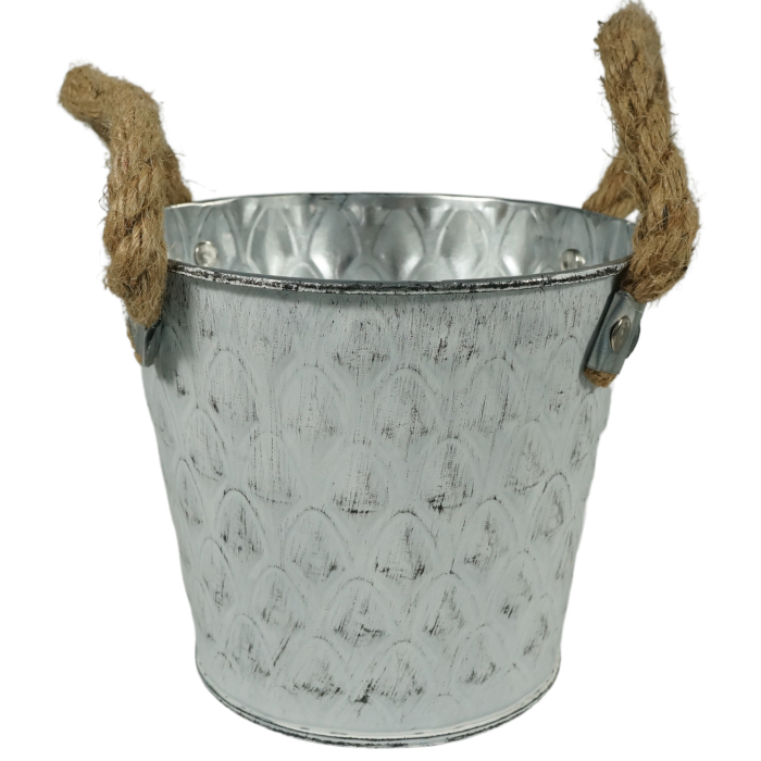 Biała metalowa osłonka na kwiaty w kształcie wiaderka o średnicy 14 cm. Posiada ozdobne uchwyty ze sznura i postarzany wzór, idealna do dekoracji wnętrz.
