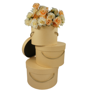 Zestaw 3 flowerboxów kraft z pokrywkami i uchwytami ze sznura wypełnionych sztucznymi kwiatami w odcieniach pomarańczy.