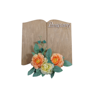 Drewniana książka w kolorze brązowym o wymiarach 29x31 cm z ozdobnym napisem Pamiętamy, udekorowana kwiatami. Idealna jako statuetki na kwiaty i znicze, stanowi estetyczną podstawę do dekoracji nagrobnych oraz tabliczek okolicznościowych.