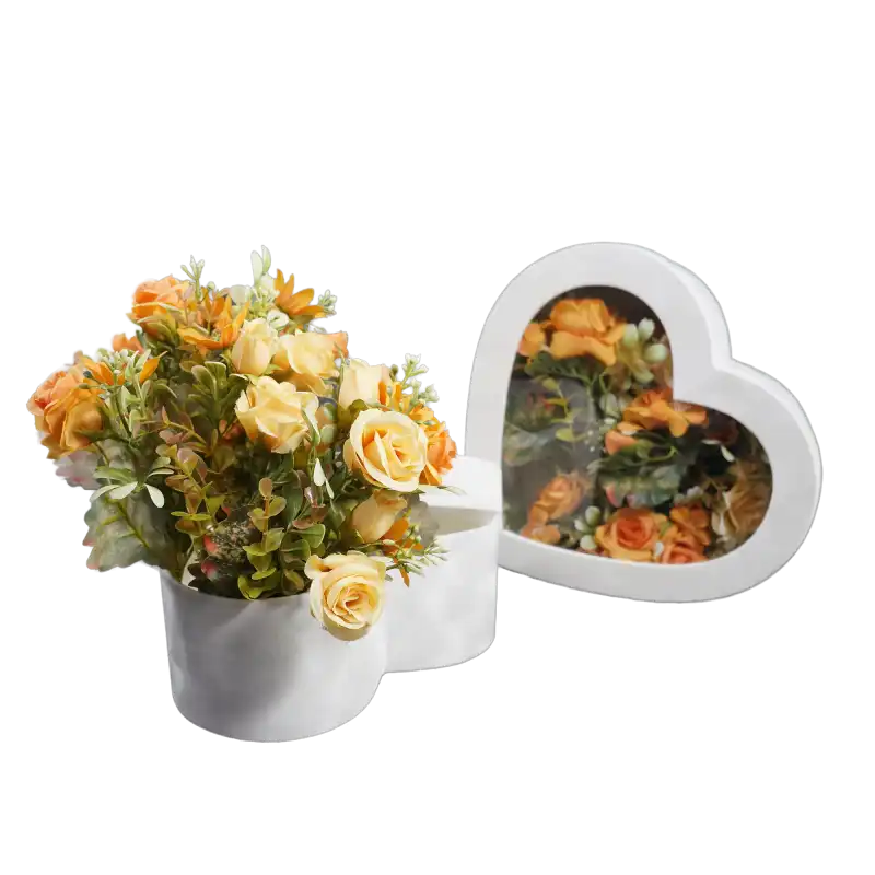 Kompozycja z welurowym flowerboxem wypełnionym pomarańczowymi kwiatami. Obok widoczna przezroczysta pokrywka, która pozwala na bezpieczne zamknięcie pudełka przy zachowaniu pełnej ekspozycji dekoracji.