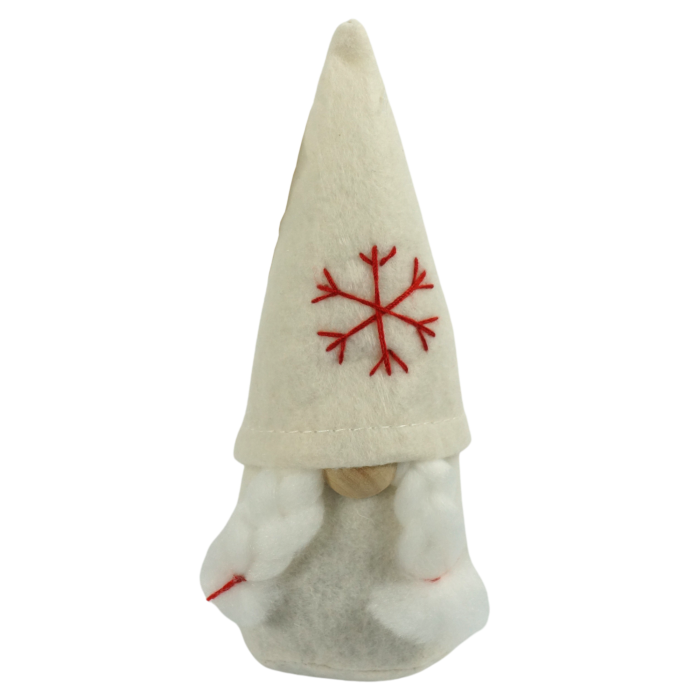 Biały filcowy skrzat Ewa o wysokości 16 cm. Figurka posiada charakterystyczną czapkę ozdobioną czerwonym haftem w kształcie płatka śniegu oraz białe warkocze, co nadaje jej świątecznego charakteru.