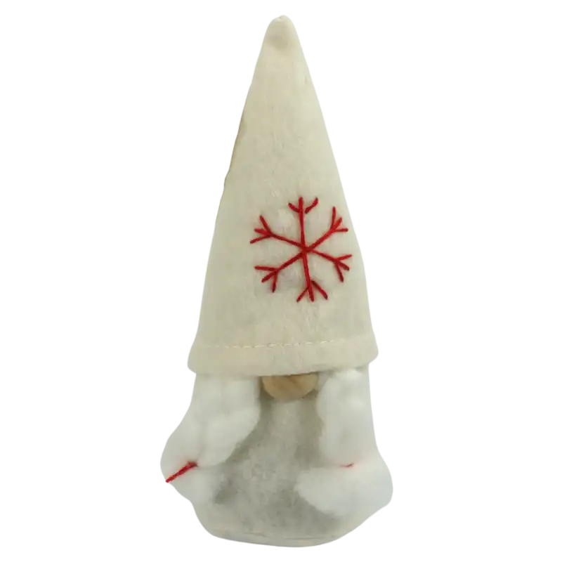 Biały filcowy skrzat Ewa o wysokości 16 cm. Figurka posiada charakterystyczną czapkę ozdobioną czerwonym haftem w kształcie płatka śniegu oraz białe warkocze, co nadaje jej świątecznego charakteru.