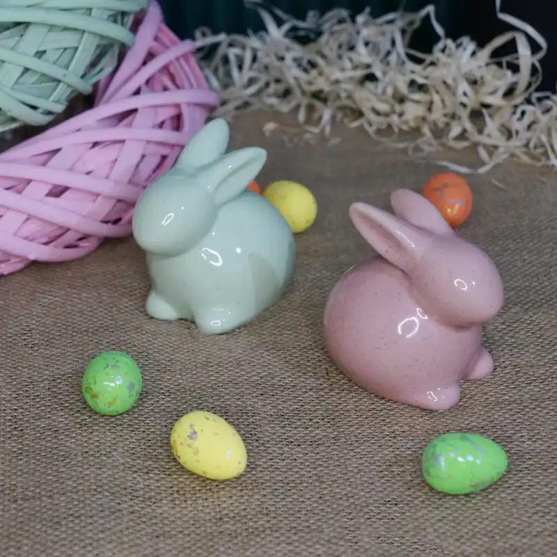 Zając ceramiczny 9 cm w otoczeniu wielkanocnych jajek. Subtelna dekoracja wykonana z ceramiki, idealna jako element świątecznej kompozycji w nowoczesnym wnętrzu.