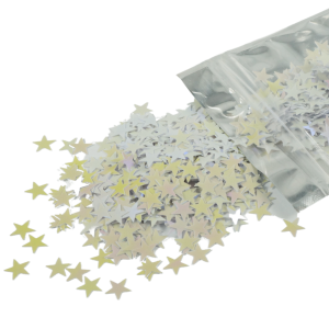 Confetti gwiazdki 20 g o rozmiarze 1 cm rozsypane na powierzchni, wysypujące się z foliowego opakowania. Dekoracja zmieniająca barwę od bieli po róż.