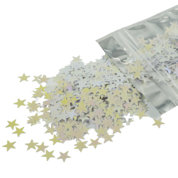 Confetti gwiazdki 20 g o rozmiarze 1 cm rozsypane na powierzchni, wysypujące się z foliowego opakowania. Dekoracja zmieniająca barwę od bieli po róż.