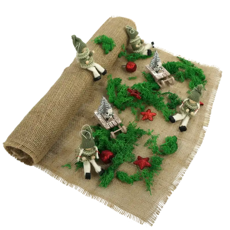 Tkanina jutowa wykorzystana jako tło do świątecznej dekoracji z mchem, figurkami krasnali i małymi saniami. Naturalna juta o szerokości 48 cm stanowi bazę dla kompozycji.