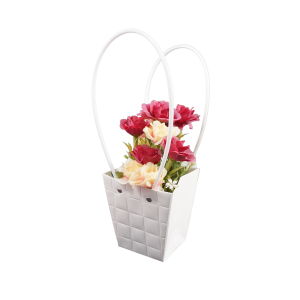 Kompozycja kwiatowa w białej torebce prezentowej o wysokości 32 cm, ujęta z profilu dla podkreślenia formy i uchwytów.