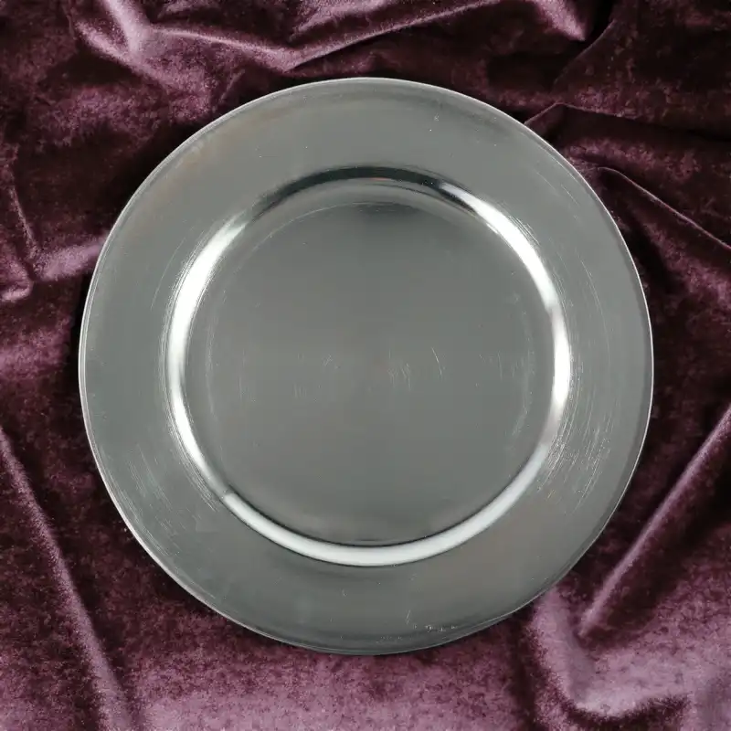 Gładka powierzchnia srebrnej patery 33 cm wyeksponowana na tle głębokiego, fioletowego weluru. Elegancki sposób na podkreślenie metalicznego połysku dekoracji.