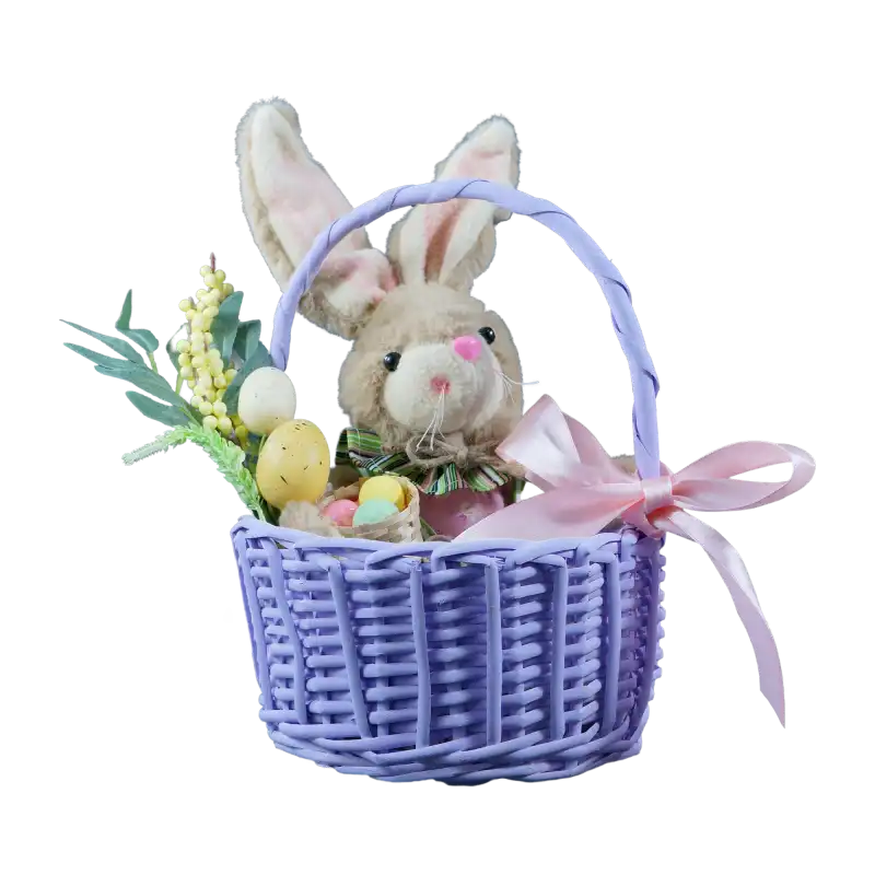 Fioletowy koszyk wiklinowy ⌀ 22 cm wypełniony wielkanocną dekoracją z pluszowym zajączkiem, pisankami i różową kokardą.