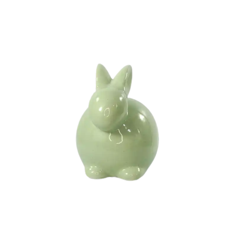 Pojedynczy zielony zając ceramiczny o wysokości 13 cm na czystym białym tle. Prezentacja nowoczesnej formy dekoracji, która pasuje do wnętrz w każdym stylu.