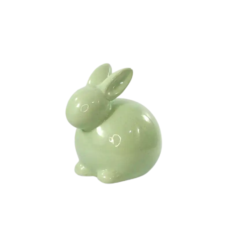 Zbliżenie na zielonego zająca ceramicznego o wysokości 13 cm, ukazujące gładką powierzchnię i subtelną, pastelową kolorystykę tej wiosennej figurki dekoracyjnej.