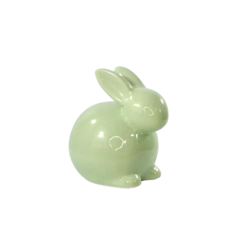 Zielony zając ceramiczny o wysokości 13 cm, sfotografowany z lekkiego skosu, co pozwala dokładnie przyjrzeć się nowoczesnemu kształtowi i wykończeniu ceramiki.