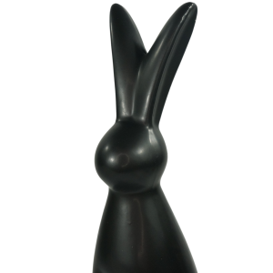 Zbliżenie na górną część czarnego zająca ceramicznego. Ukazuje gładką powierzchnię i charakterystyczny kształt uszu dekoracyjnej figurki wielkanocnej.