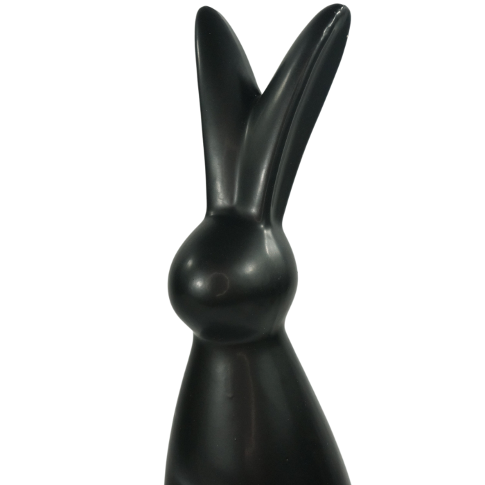 Zbliżenie na górną część czarnego zająca ceramicznego. Ukazuje gładką powierzchnię i charakterystyczny kształt uszu dekoracyjnej figurki wielkanocnej.