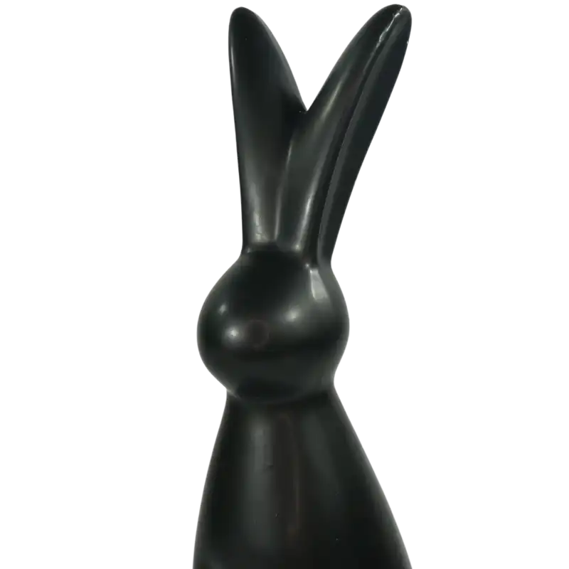 Zbliżenie na górną część czarnego zająca ceramicznego. Ukazuje gładką powierzchnię i charakterystyczny kształt uszu dekoracyjnej figurki wielkanocnej.