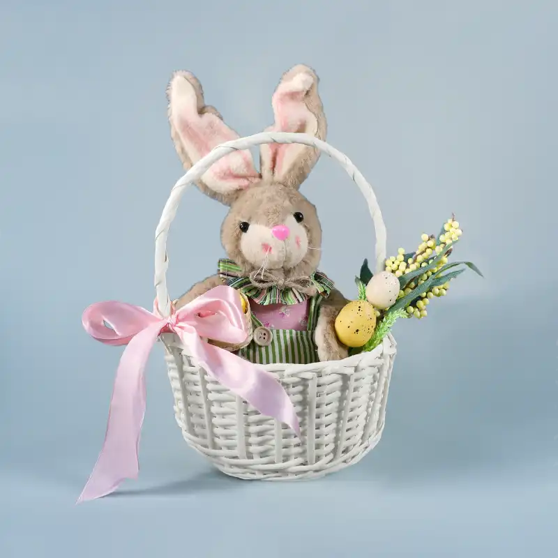 Aranżacja z koszem wiklinowym ecru 22 cm, w którym umieszczono wielkanocne ozdoby. Widok na pastelową różową kokardę.