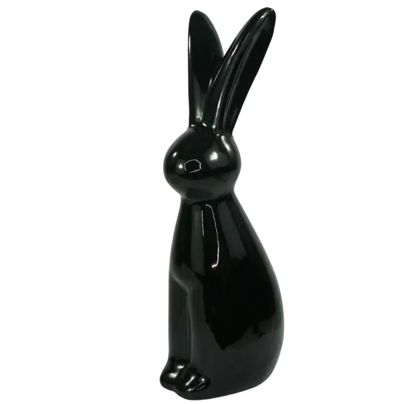 Czarny zając ceramiczny ustawiony w lekkim skosie, podkreślający jego minimalistyczny charakter w aranżacji.