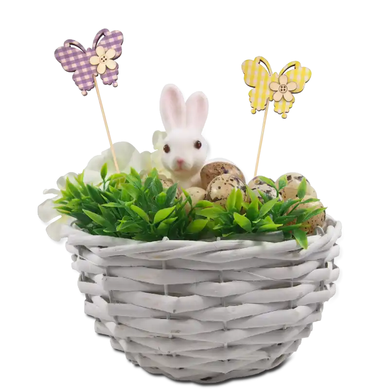 Żółty motyl na piku umieszczony w wielkanocnej kompozycji w białym koszyczku wraz z figurką zająca, jajkami i zielonymi gałązkami. Idealna inspiracja na wiosenny stroik.