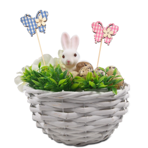 Wiosenny stroik w wiklinowym koszyku z figurką zajączka, jajkami i niebieskim motylem na piku. Kompozycja prezentuje praktyczne zastosowanie ozdoby o długości 24 cm w dekoracjach wnętrz.