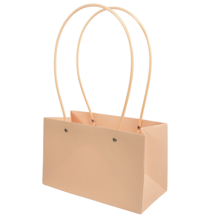Łososiowa papierowa torebka na kwiaty 35x22 cm z dwoma uchwytami, ukazana w ujęciu z półprofilu, prezentująca estetyczną formę opakowania prezentowego.