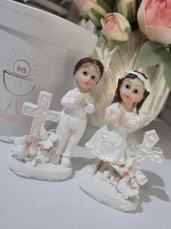 Zestaw dwóch figurek komunijnych chłopca i dziewczynki przy krzyżach, doskonałe jako prezenty na komunię.