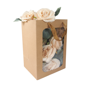 Zbliżenie na kraftową torebkę prezentową 30x20x16 cm z bukietem jasnych róż, podkreślające naturalny odcień papieru.