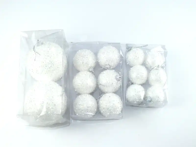 Zestaw dekoracji świątecznych przedstawiający białe bombki o średnicy 6 cm w oryginalnych opakowaniach jednostkowych.