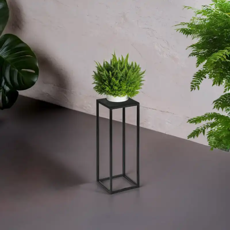 Czarny kwietnik metalowy loft 40x15x15 cm z rośliną doniczkową, widoczny w nowoczesnym wnętrzu na tle jasnej ściany.