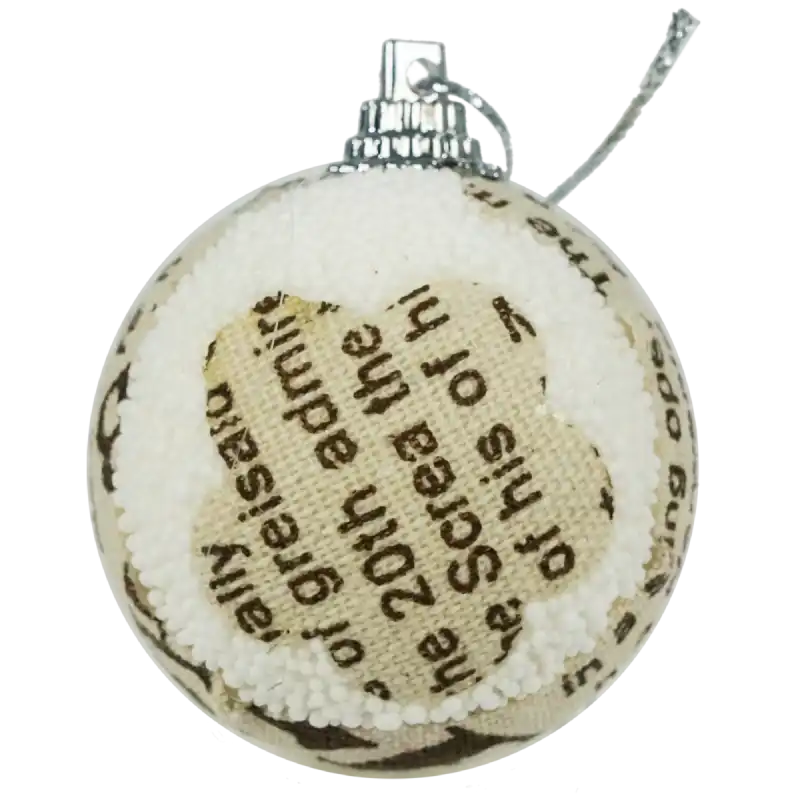 Detale nadruku na bombce o średnicy 5 cm, widoczne napisy i tekstura materiału użytego do zdobienia ozdoby.
