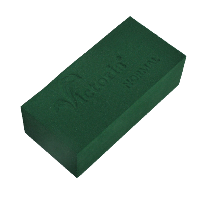 Mokra gąbka florystyczna Victoria Normal do kwiatów żywych o wymiarach 23x11x7,5 cm. Zielona kostka o regularnym kształcie prostopadłościanu z wytłoczonym logo marki na górnej powierzchni.