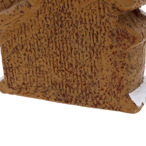 Zbliżenie na boczną ściankę ceramicznej ozdoby. Faktura materiału przypomina naturalnie pieczone ciasto piernikowe, co nadaje dekoracji realizmu.