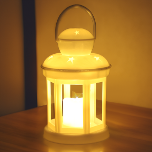 Lampion LED w gwiazdki ustawiony na drewnianym podłożu w wieczornej scenerii. Ciepłe światło lampionu tworzy przytulny klimat w pomieszczeniu.