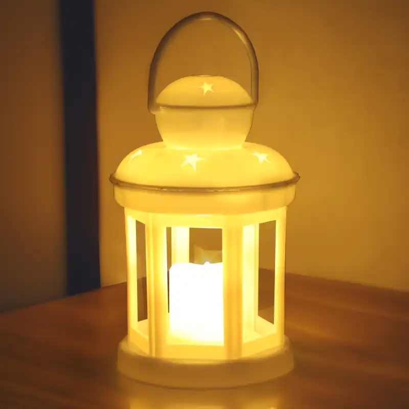 Lampion LED w gwiazdki ustawiony na drewnianym podłożu w wieczornej scenerii. Ciepłe światło lampionu tworzy przytulny klimat w pomieszczeniu.