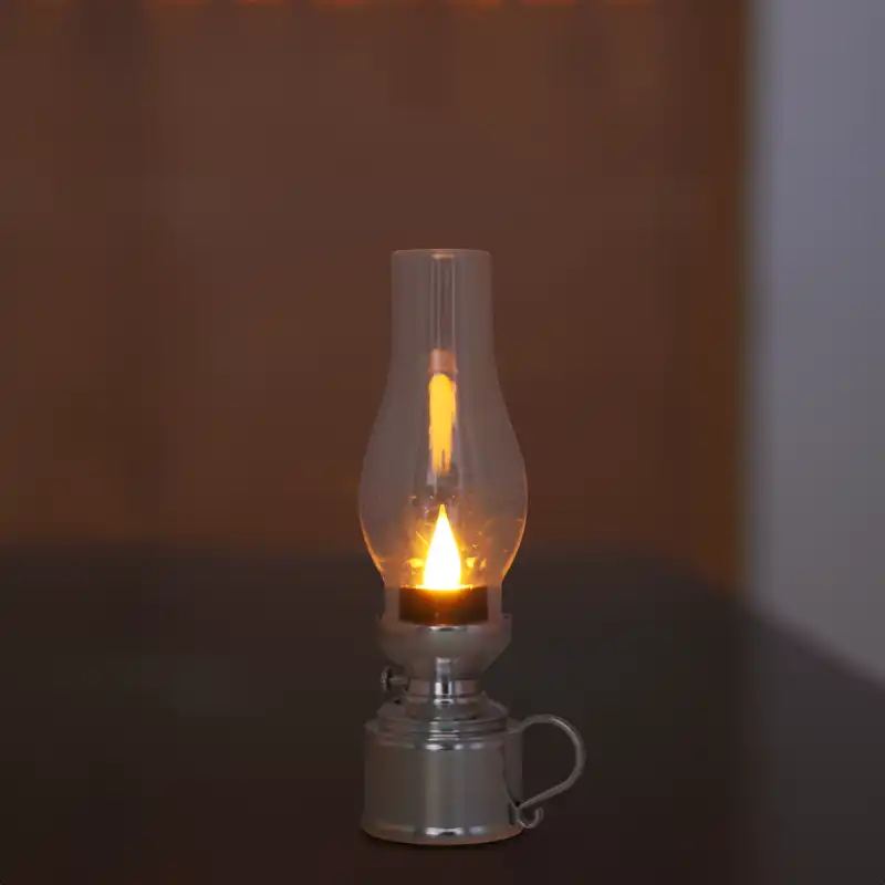 Prezentacja srebrnej lampy naftowej LED w wieczornej scenerii. Ciepły blask imitujący świecę podkreśla świąteczny charakter.