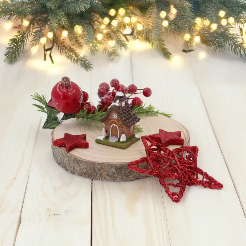 Miniaturowy domek 6 cm w zimowej aranżacji na tle gałązek świerkowych i ciepłych świateł lampek choinkowych.